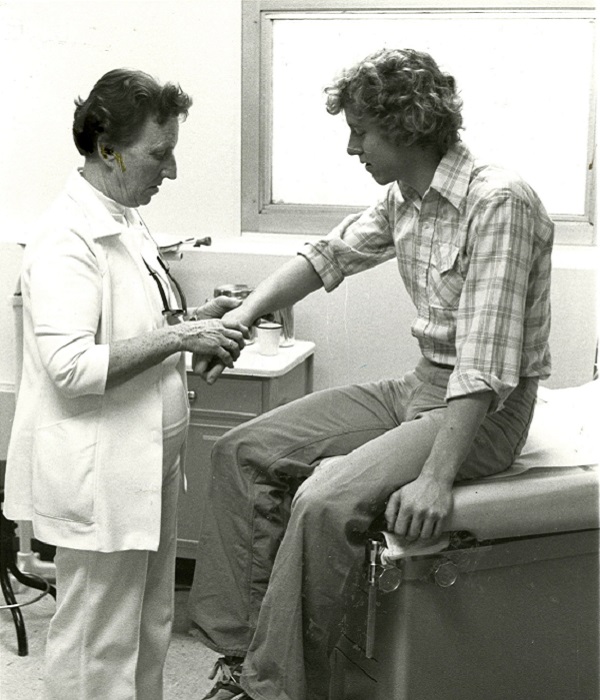 Rita Black examines a patient's wrist, 1979, black and white photo