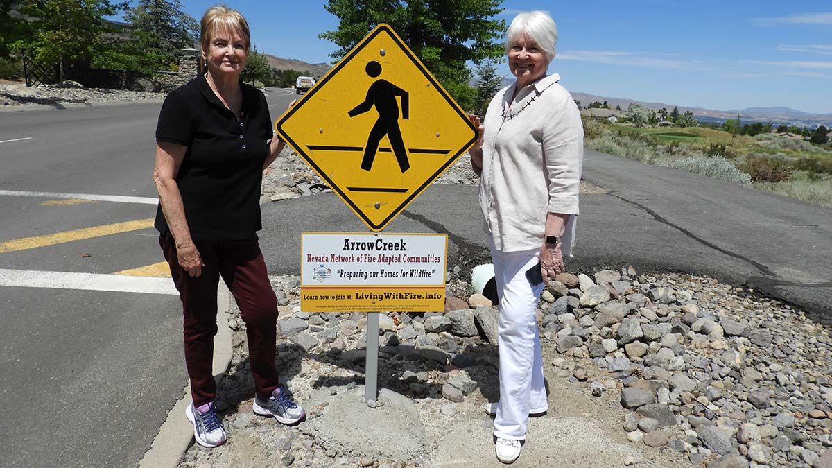 Kathi Delegal and Janet Ouren by Fire Adapted Community sign
