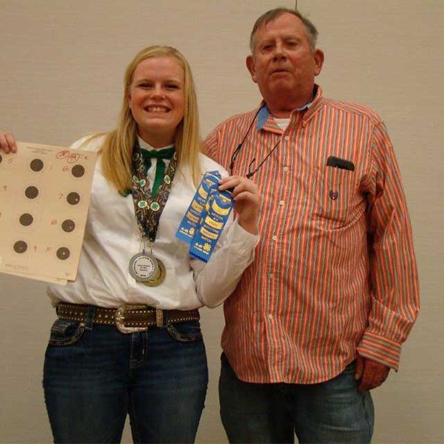 Tom Crowley with a 4-H'er who is holding her medals and ribbons