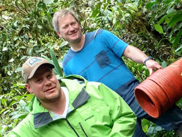 Two researchers smiling while working in the rainforest.