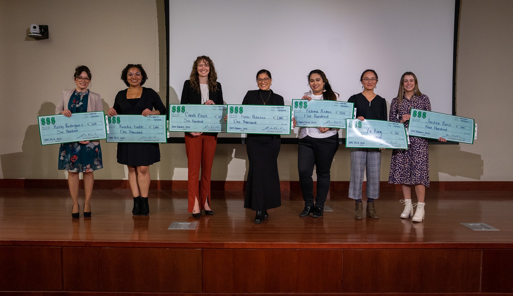 3MT winners posing as a group with large checks