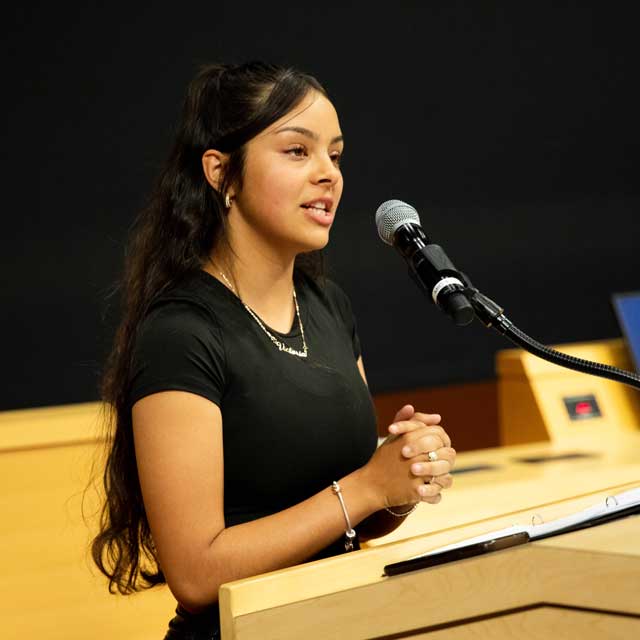 Victoria Gallegos speaking at a podium