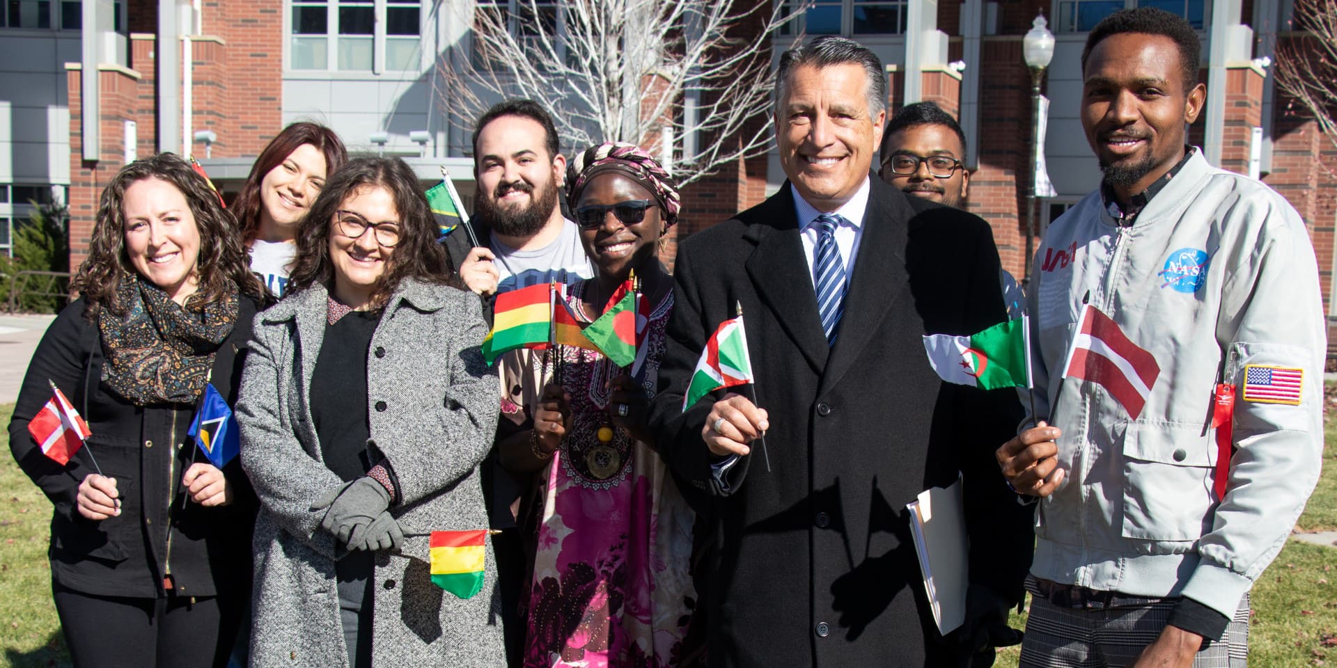 President Sandoval with students holding small flags from many countries.
