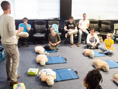 An EH&S personnel conducting a CPR training class in a room with participants