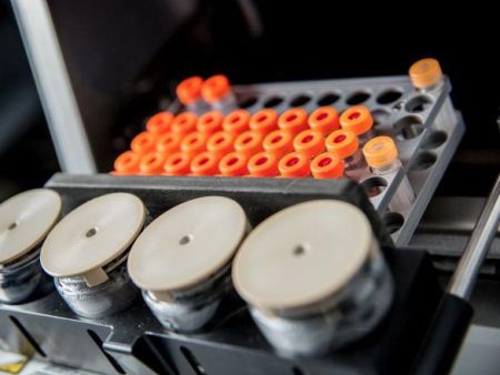Close-up of a tray of vials with bright orange lids
