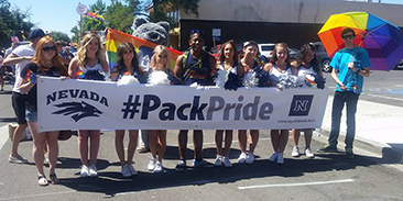 Students, cheerleaders and mascot with Pack Pride banner