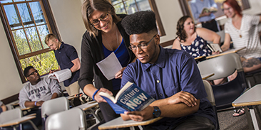 Student receives instruction from female professor in classroom