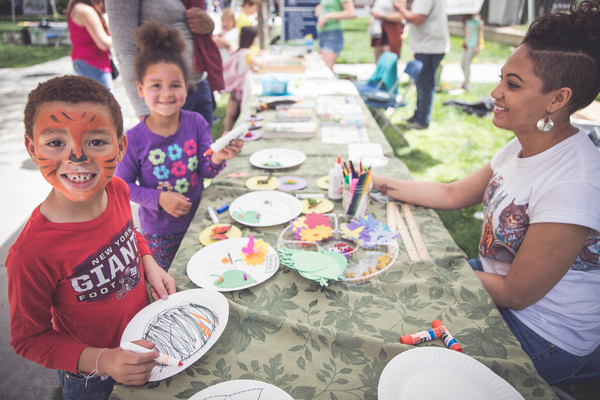 A brother and sister build bug ecosystems on paper plates outside the Museum.