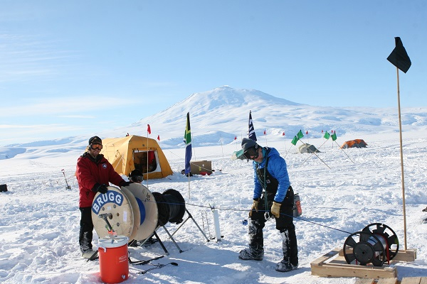 Researchers working with spools of cable at the Antarctica research station