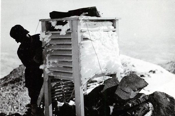 Researcher breaking rime ice off the equipment in winter