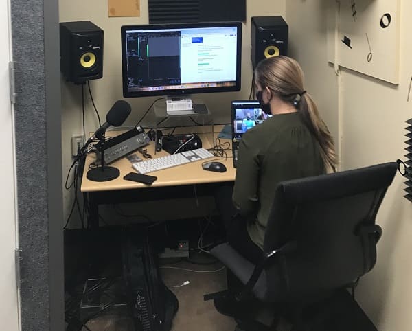 Michelle Rebaleati conducting the Foundation Video audio recording from the DeLaMare Sound Recording Room. There were two high-quality recording locations, the Mathewson-IGT Knowledge Center and DeLaMare Science and Engineering Library, while all participants were connected virtually over Zoom. 