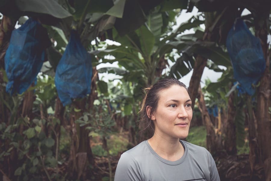 Dani Salcido standing in front of a row of banana trees