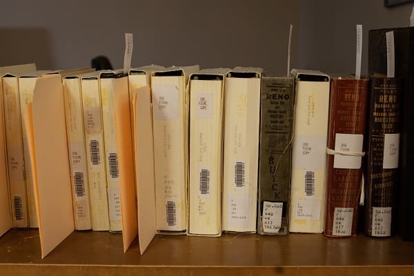 Volumes of records prepared for digitization with notes and extra papers stuck into them