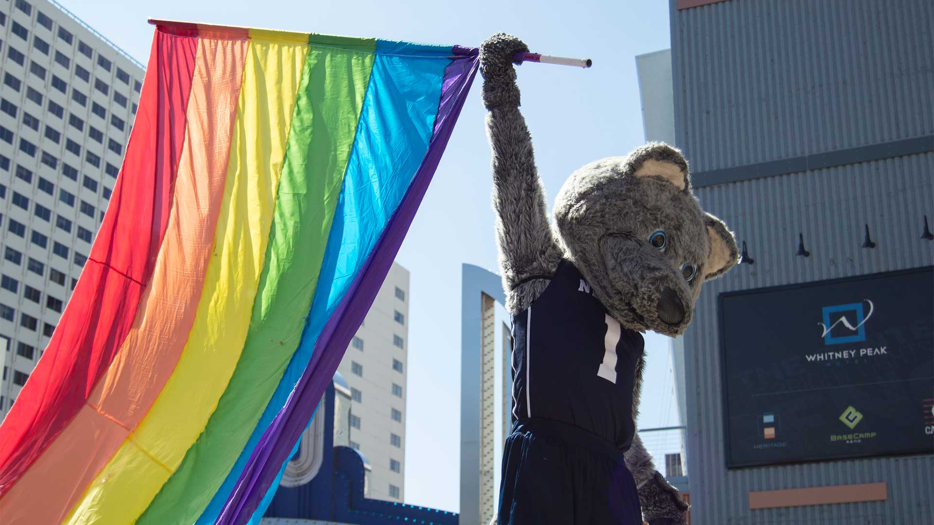 Mascot Alphie holds the Pride flag aloft in downtown Reno