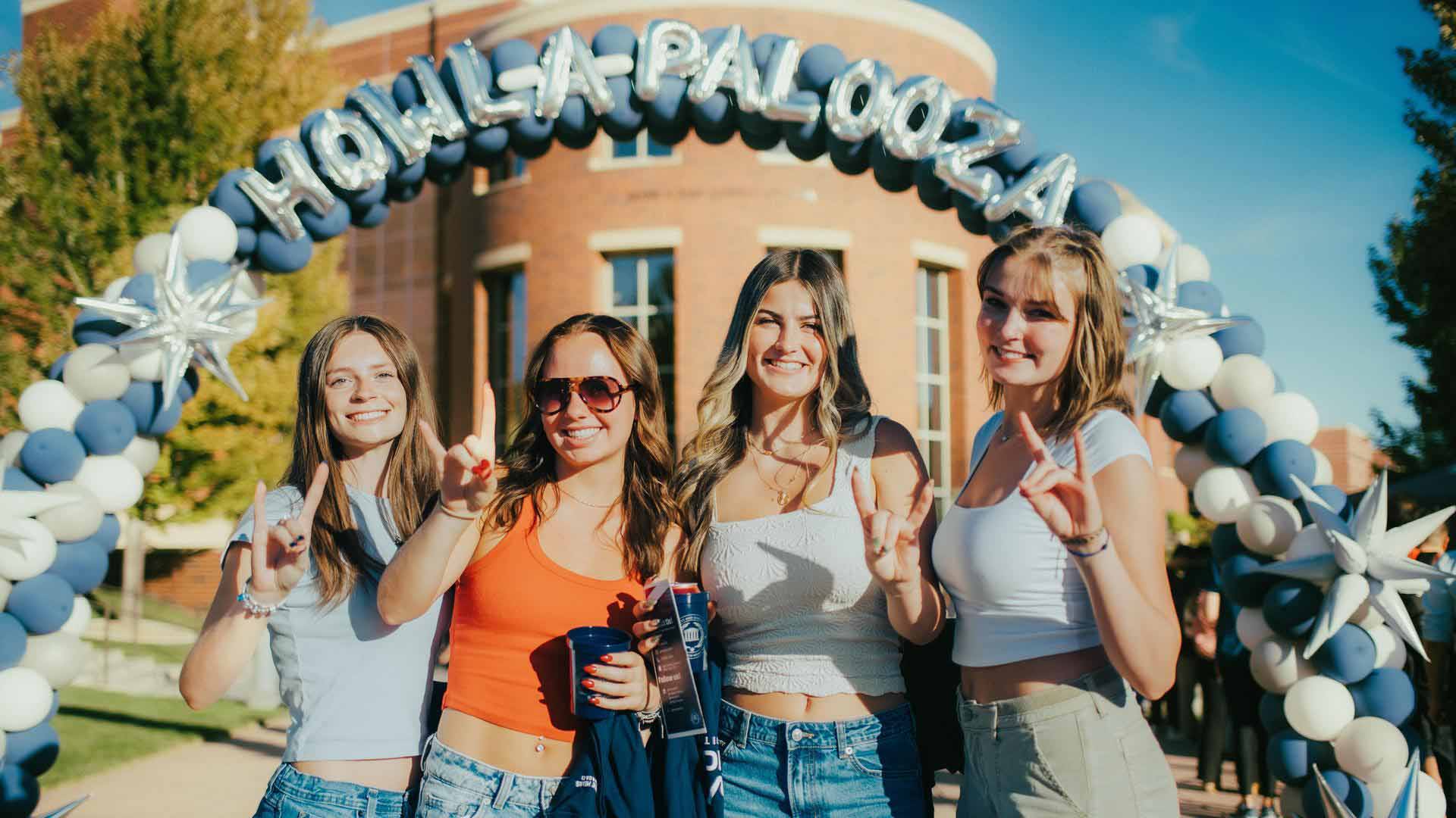 University of Nevada, Reno students pose under a Howl-a-palooza balloon banner. 