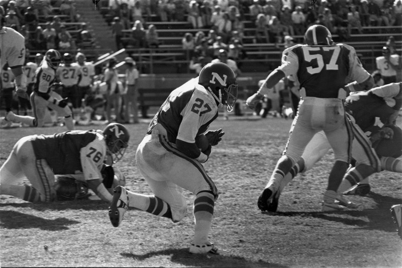 Frank Hawkins runs with the football while his teammates clear a path