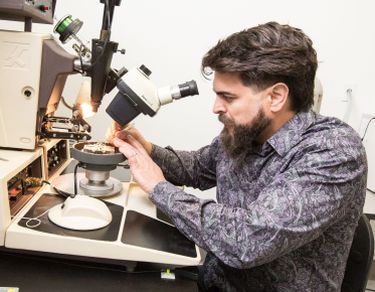 NevadaNano employee and University alumnus working in high-tech laboratory.