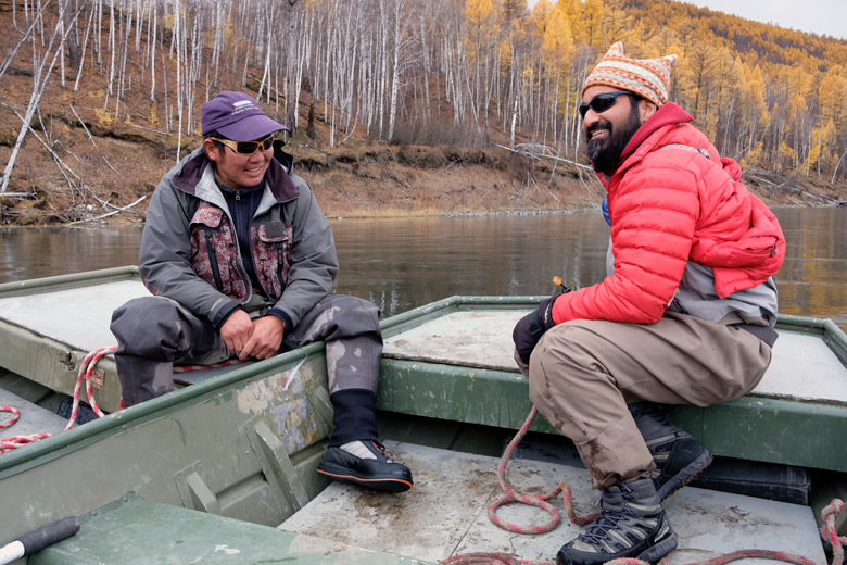 Sudeep Chandra sits on a boat with Mongolian fishing guide, Gonzarig.