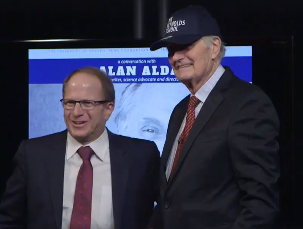 Alan Alda wears Reynolds School of Journalism baseball cap and poses with Dean Al Stavitsky