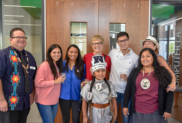 Faculty and community members pose for a photo in the new Great Basin Hall.