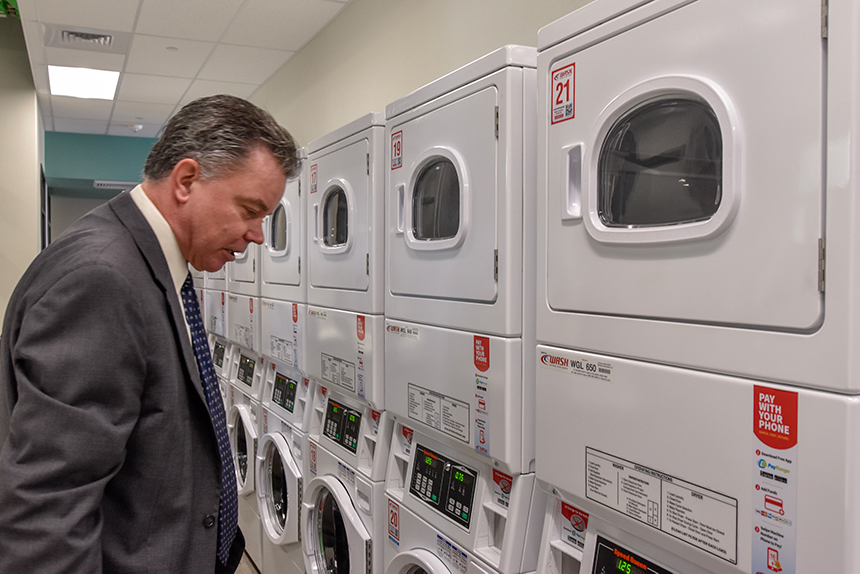 Provost Kevin Carman looking at the laundry room in Great basin hall.