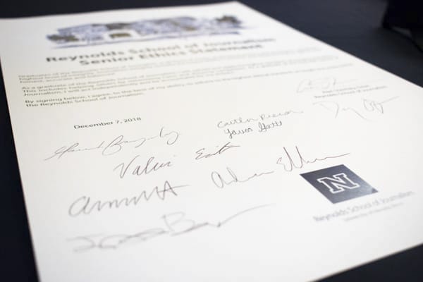 Signed Reynolds School senior oath sits on a table.