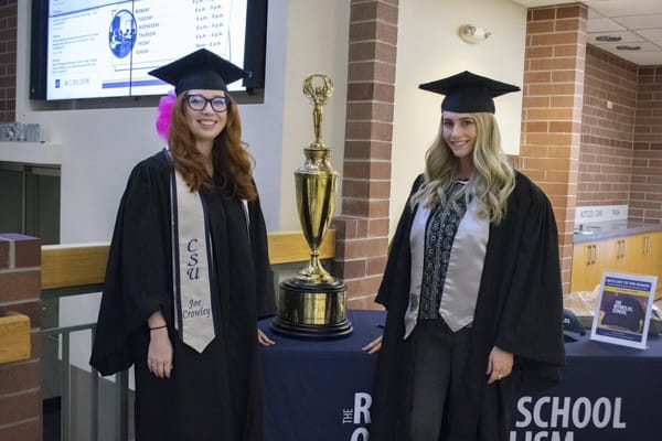 Two students pose by the IMC trophy.