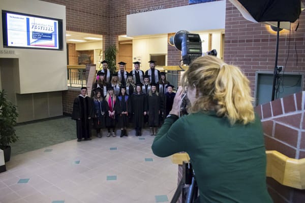 The photographer takes photos of the graduating class on the atrium steps.