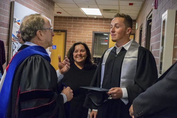 A student and parents talk with the dean.