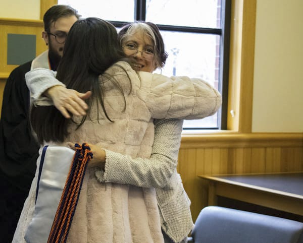 A faculty member and student hug.