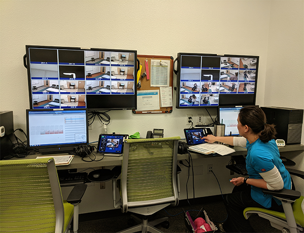 Alisha Fong, UNR Med simulation technician, watches live footage on video screens as students participated in the research study