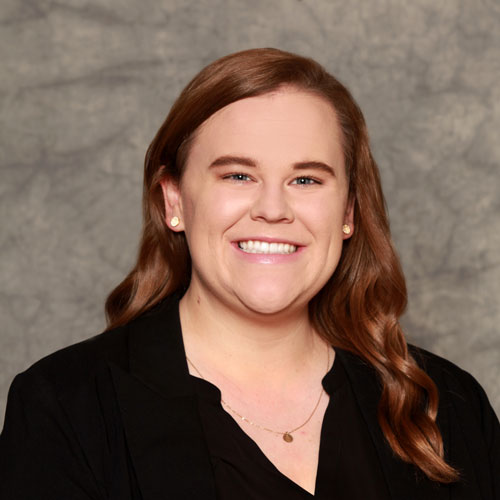 Woman poses in front of a backdrop