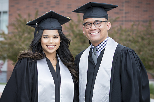 Two happy graduates outside the Asian American & Pacific Islander Graduate Celebration