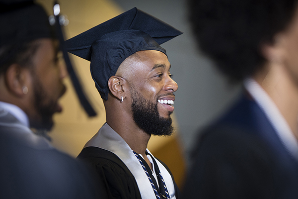 A smiling graduate at the African Diaspora Graduate Celebration with friends