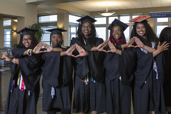 Graduates joining hands at the African Diaspora Graduate Celebration