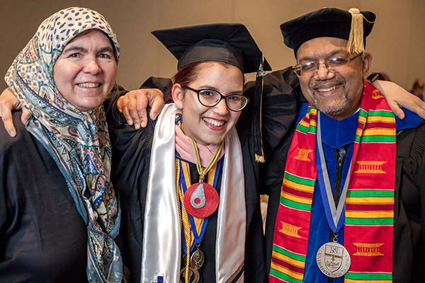 A graduate with faculty members at the American Indian & Alaskan Native Graduate Celebration