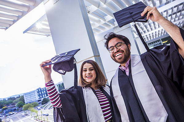 Graduates holding up their caps outside the Latinx Graduate Celebration