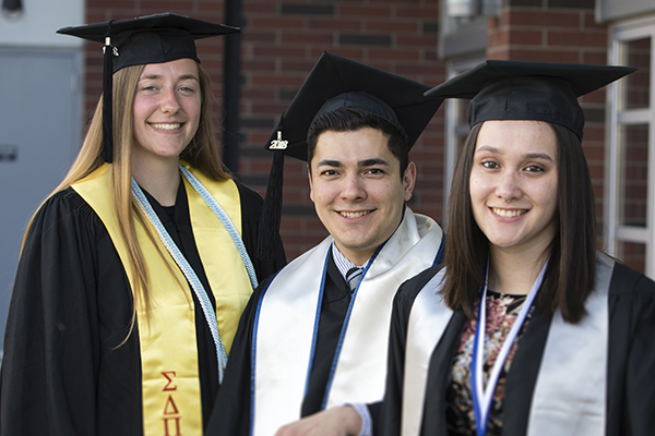 Three graduates posing outside the Lavender Graduate Celebration