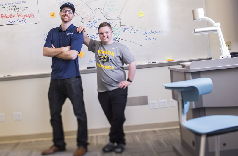 Jack and Riley standing next to each other behind a white board