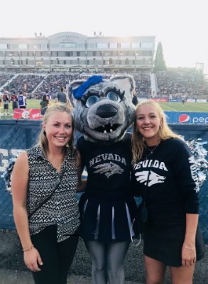 Carina stands next to Luna the mascot at her first football game