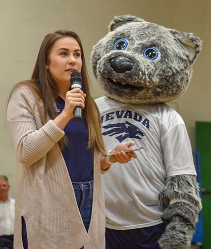 Student Body President Hannah Jackson address middle school students at a pep rally at Clayton Middle School with mascot Wolfie Jr. standing next to her