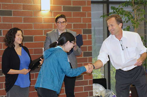 Graduate Dean shaking student's hand during award ceremony.