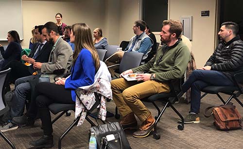 People sitting in a room listening to a presentation