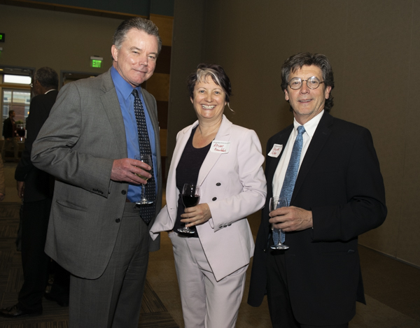 University faculty and guests pose indoors.