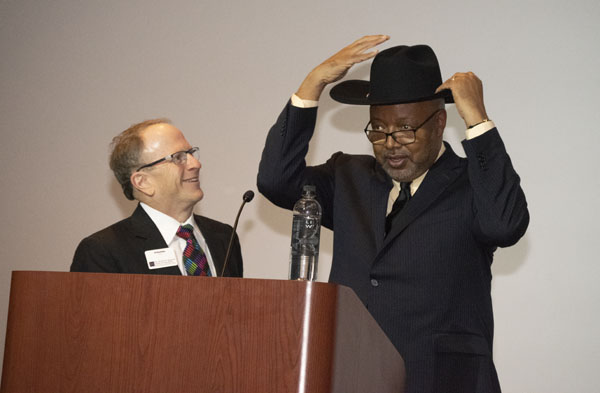 Leonard Pitts Jr. puts on a Stetson cowboy hat next to dean Stavitsky.