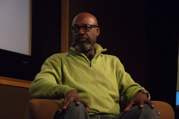 Faculty member sits on stage.