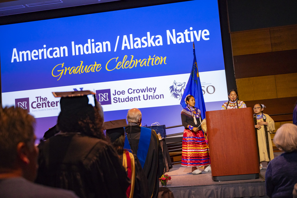 The crowd attends to speakers in traditional clothing at the American Indian & Alaskan Native Graduate Celebration