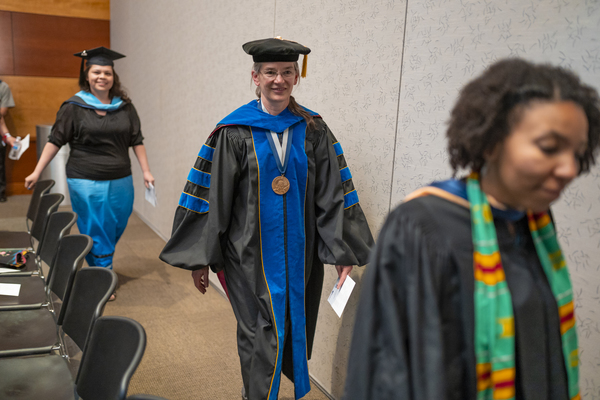 Graduates and faculty members walking to the stage at the American Indian & Alaskan Native Graduate Celebration