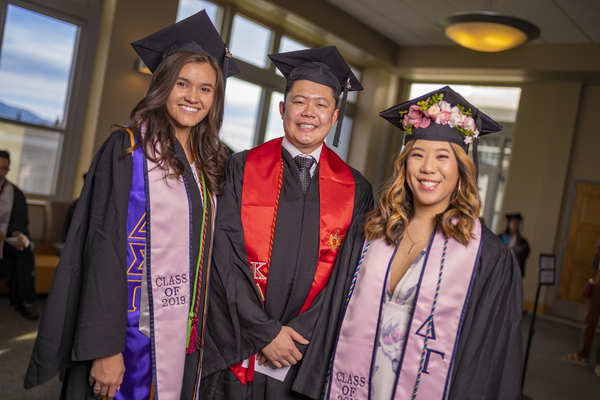 Three happy graduates outside the Asian American & Pacific Islander Graduate Celebration