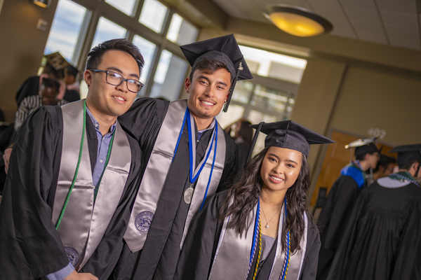 Three happy graduates at the Asian American & Pacific Islander Graduate Celebration